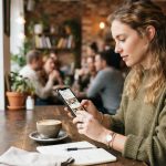 Person checking restaurant reviews before choosing a dining location